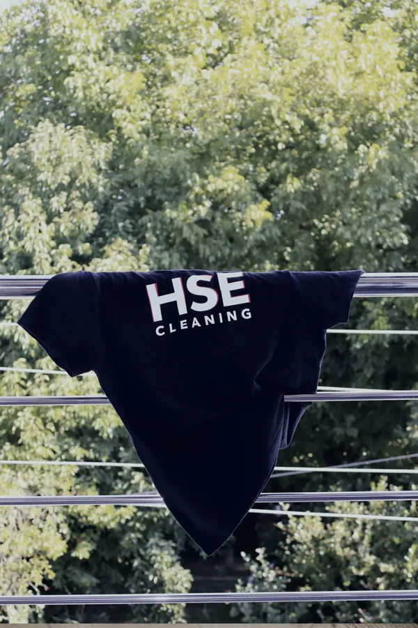 Crna HSE Cleaning majica suši se na balkonu